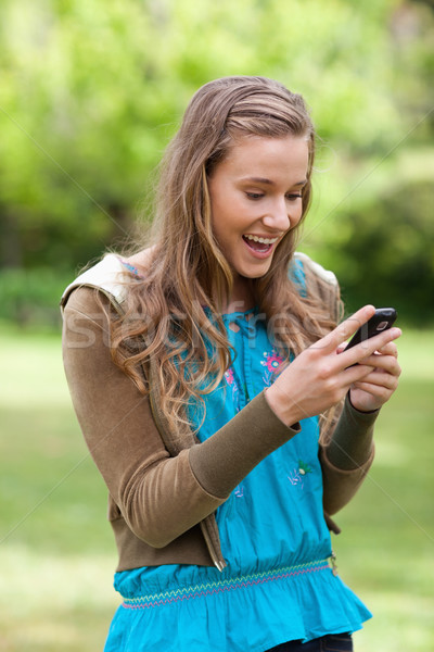 Adolescent surprinzator text telefon mobil în picioare parc Imagine de stoc © wavebreak_media