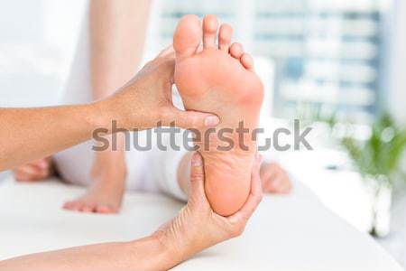 Doctor holding the foot of a woman in his office Stock photo © wavebreak_media