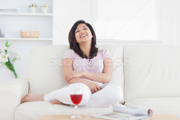 Mujer riendo sofá salón vino Foto stock © wavebreak_media