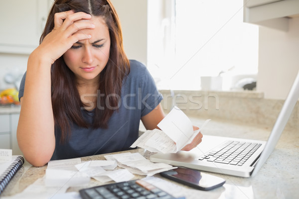 Brunette looking worried over bills in kitchen Stock photo © wavebreak_media