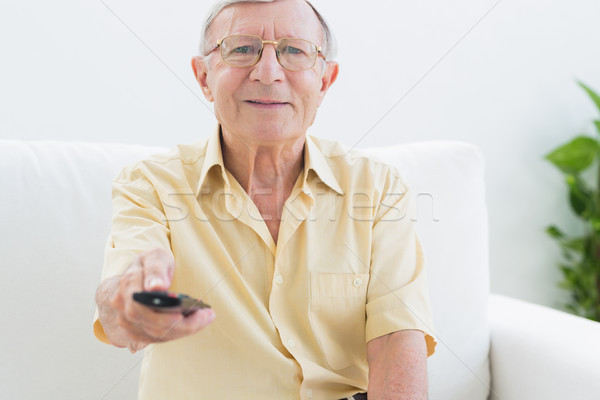 Sorridente idoso homem remoto sofá casa Foto stock © wavebreak_media