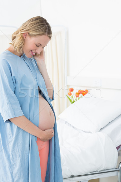 Smiling pregnant woman looking at belly Stock photo © wavebreak_media