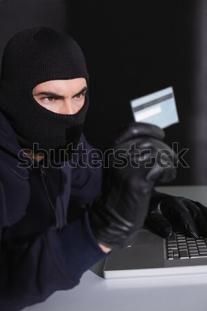 Focused burglar standing holding laptop Stock photo © wavebreak_media