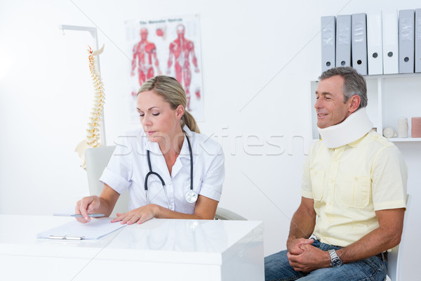 Doctor examining her patient wearing neck brace Stock photo © wavebreak_media