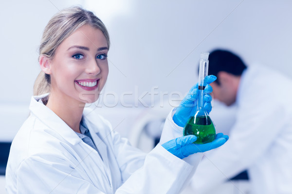 Science student holding green chemical in beaker Stock photo © wavebreak_media