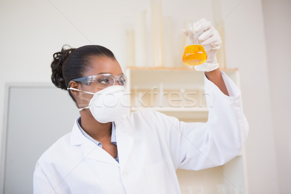 Scientist examining petri dish with orange fluid inside Stock photo © wavebreak_media