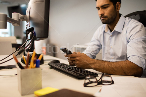 Businessman using mobile phone while sitting at office Stock photo © wavebreak_media