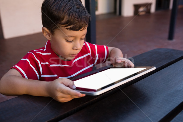 Close up of boy using digital tablet while sitting at table Stock photo © wavebreak_media