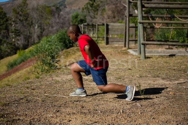 Boy performing stretching exercise during obstacle course training Stock photo © wavebreak_media