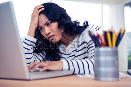 Konzentrierter asian Frau Hand Kopf mit Laptop Stock foto © wavebreak_media