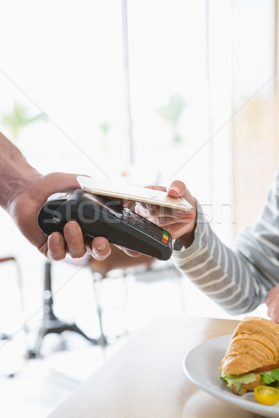 Stock photo: Woman making payment through NFC