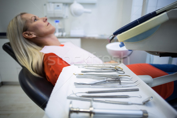 Woman relaxing on dentist chair with dental tools on foreground Stock photo © wavebreak_media