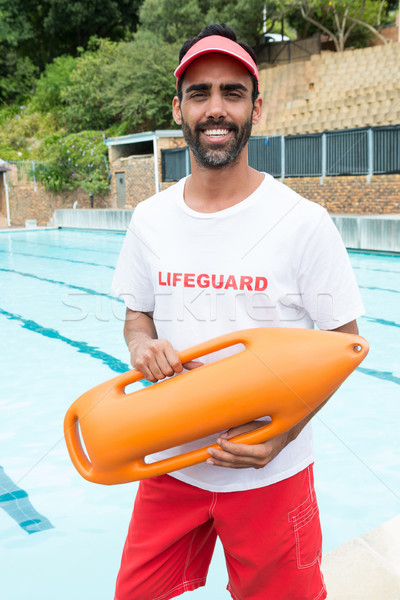 Lifeguard standing with rescue buoy near poolside Stock photo © wavebreak_media