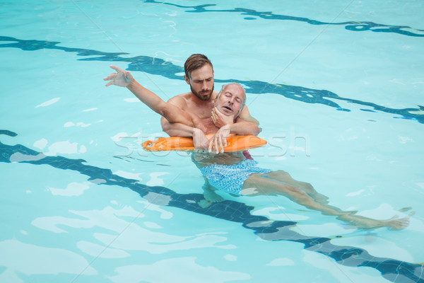 Lifeguard rescuing senior man from swimming pool Stock photo © wavebreak_media