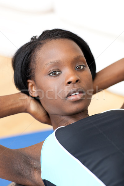 Stock photo: Concentrated woman in gym outfit doing sit-ups