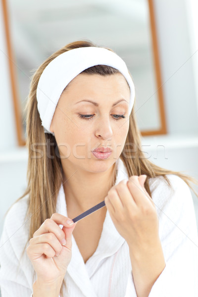 Caucasian woman doing her nails with a nail file in the bathroom Stock photo © wavebreak_media