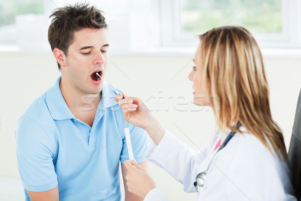 Female doctor extracting saliva from the mouth of her patient  Stock photo © wavebreak_media