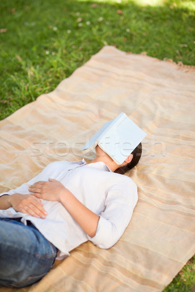 Mujer dormir libro sonrisa cara hierba Foto stock © wavebreak_media