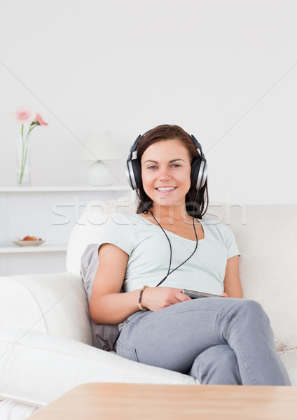 Sorrindo ouvir música sala de estar mulher sorrir beleza Foto stock © wavebreak_media