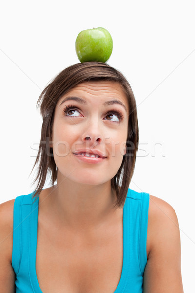 Teenager standing upright with a green apple on her head Stock photo © wavebreak_media