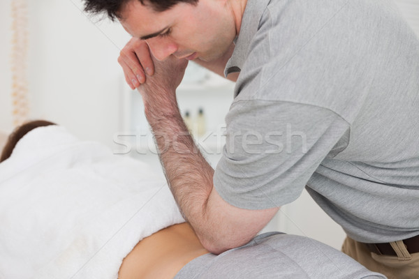 Woman lying forward while a physiotherapist is massaging her back in a physio room Stock photo © wavebreak_media