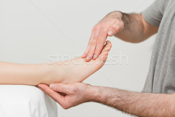 Doctor holding the foot of a patient in a room Stock photo © wavebreak_media