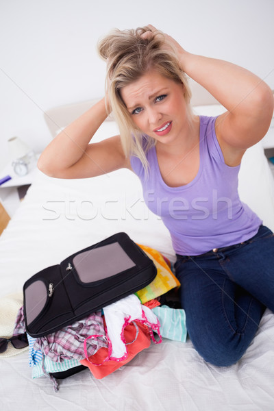 Blonde having problem to close her suitcase on her bed Stock photo © wavebreak_media