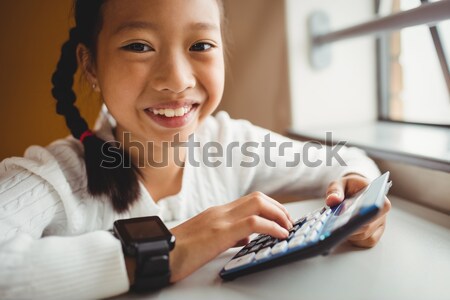 Teacher smiling while holding a tablet computer in a classroom Stock photo © wavebreak_media