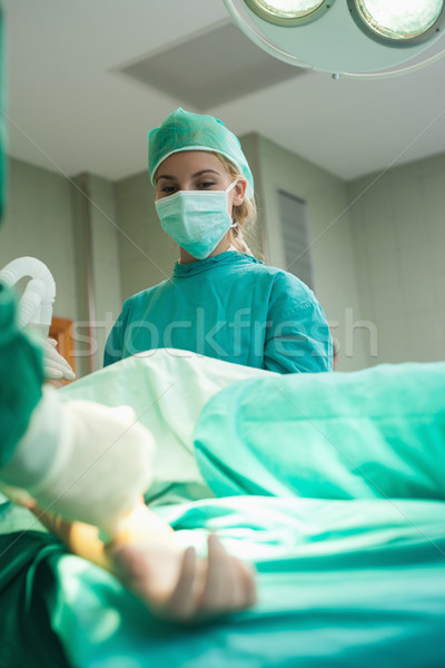 Intern watching the surgery while holding an oxygen mask Stock photo © wavebreak_media