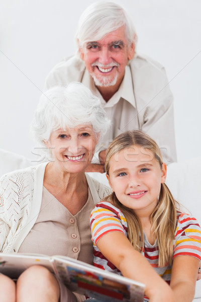 Сток-фото: девочку · улыбаясь · дедушка · и · бабушка · диване · книга · дома