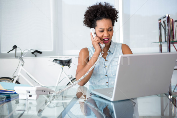 Casual young woman using telephone and laptop Stock photo © wavebreak_media