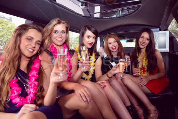 Stock photo: Happy friends drinking champagne in limousine