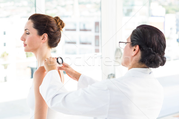 Doctor examining patient with magnifying glass Stock photo © wavebreak_media