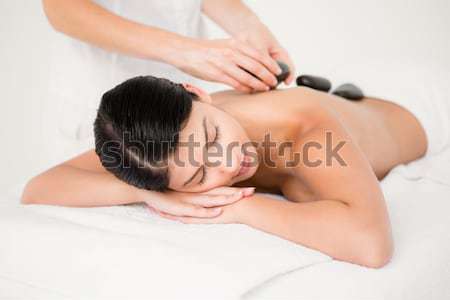Stock photo: Pretty woman receiving a hot stone massage