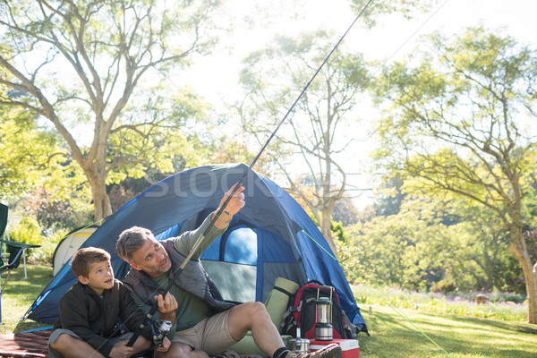 Father and son holding a fishing rod outside the tent Stock photo © wavebreak_media