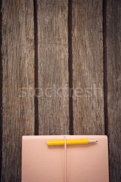 Stock photo: Overhead view of pencil with diary on wooden table