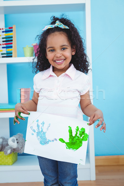 Cute girl showing paper with colored hands prints on it Stock photo © wavebreak_media