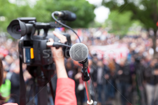 Microphone in focus against blurred crowd. Filming protest. Stock photo © wellphoto