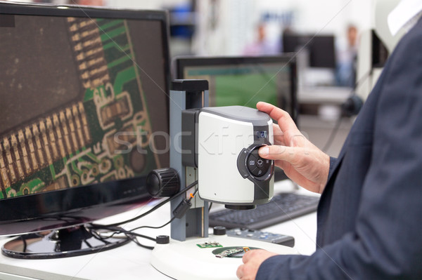  Operator working on digital microscope inspecting electronic co Stock photo © wellphoto