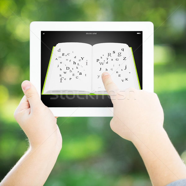 Stock photo: Man holding tablet PC with open book