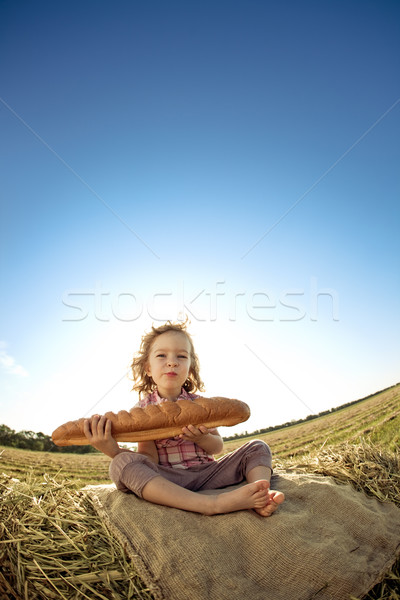 Child with bread sitting on hayrick  Stock photo © Yaruta