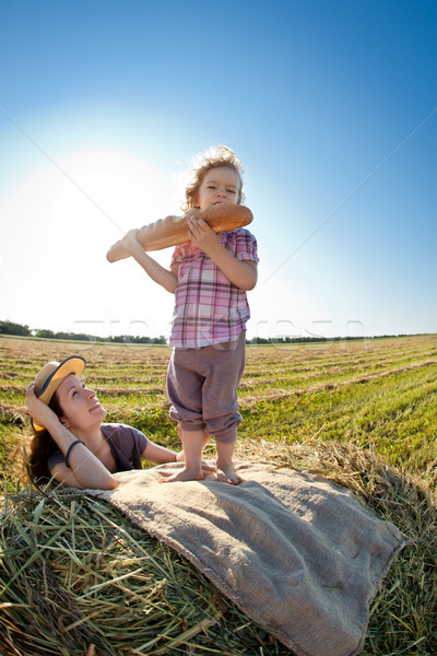 Feliz mulher criança campo de trigo alimentação pão Foto stock © Yaruta