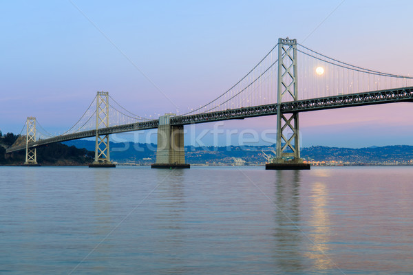 San Francisco-Oakland Bay Bridge with full moon rising and pink and blue sunset skies. Stock photo © yhelfman