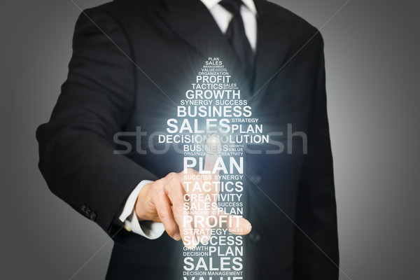 Businessman clicking on an arrow formed by business related words Stock photo © ymgerman