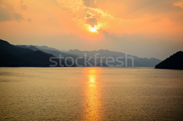 Sunset over a mountain at lake Stock photo © Yongkiet