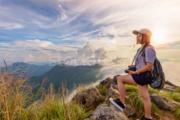 Stock photo: Girl tourist on mountains at sunset