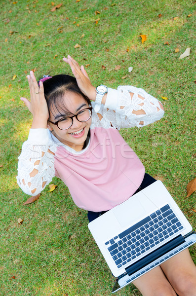 Stock photo: Cute girl is happy with notebook on grass