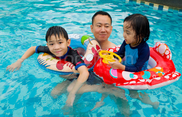 Asian famiglia nuotare tubo giocare piscina Foto d'archivio © yongtick