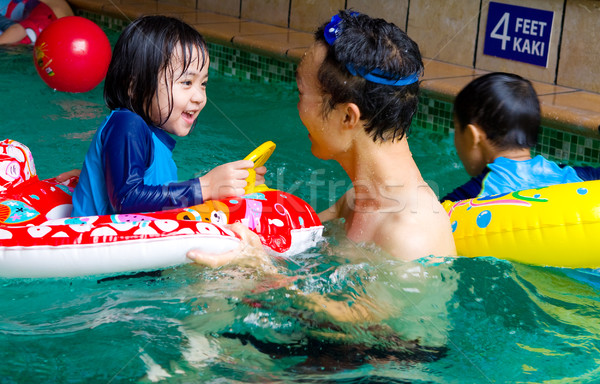 Asian famiglia nuotare tubo giocare piscina Foto d'archivio © yongtick