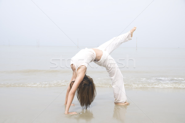 Asian ragazza yoga spiaggia cielo Foto d'archivio © yuliang11